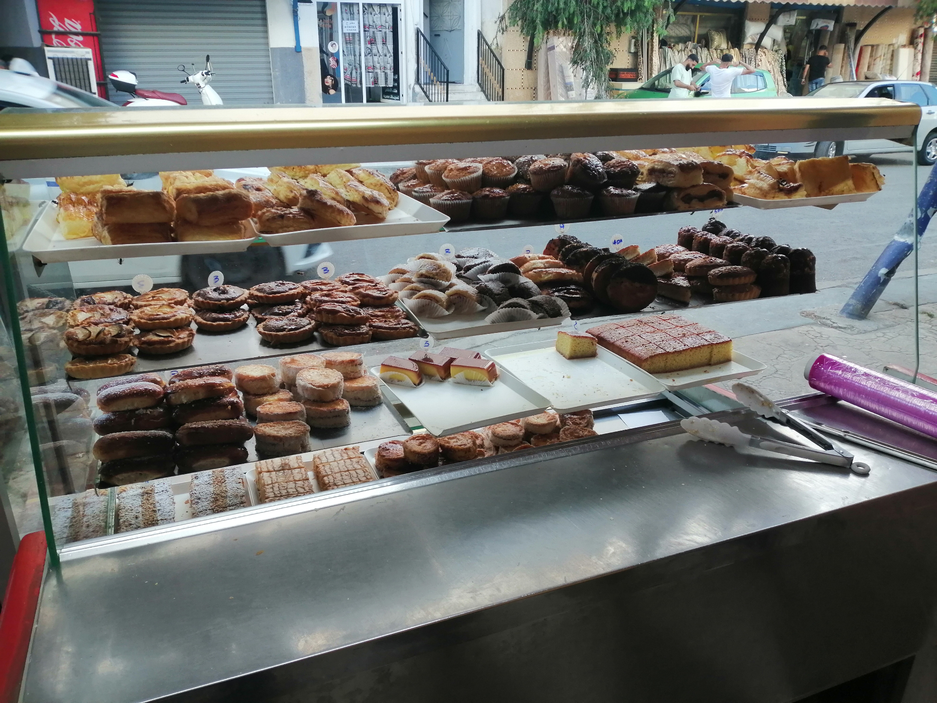 Pastry display case with tarts, muffins and cakes