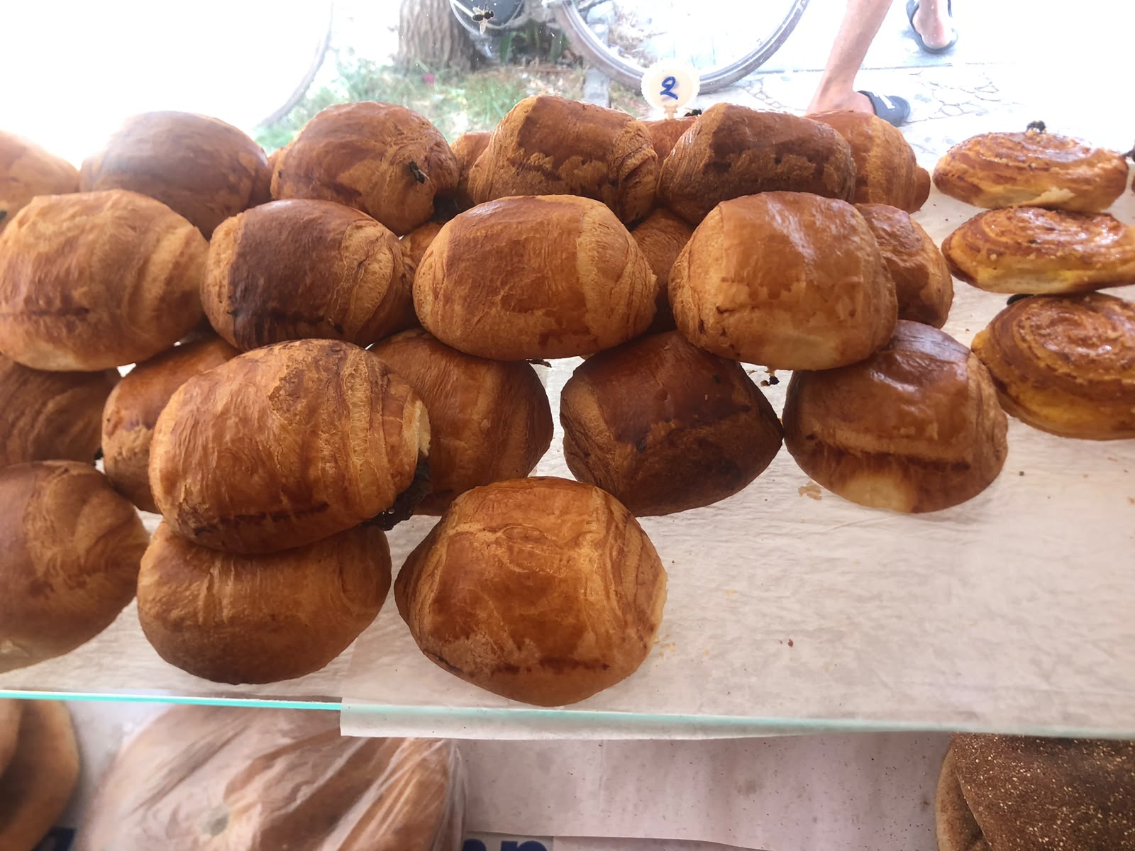 Golden brioche buns and pain au chocolat stacked on the shelf
