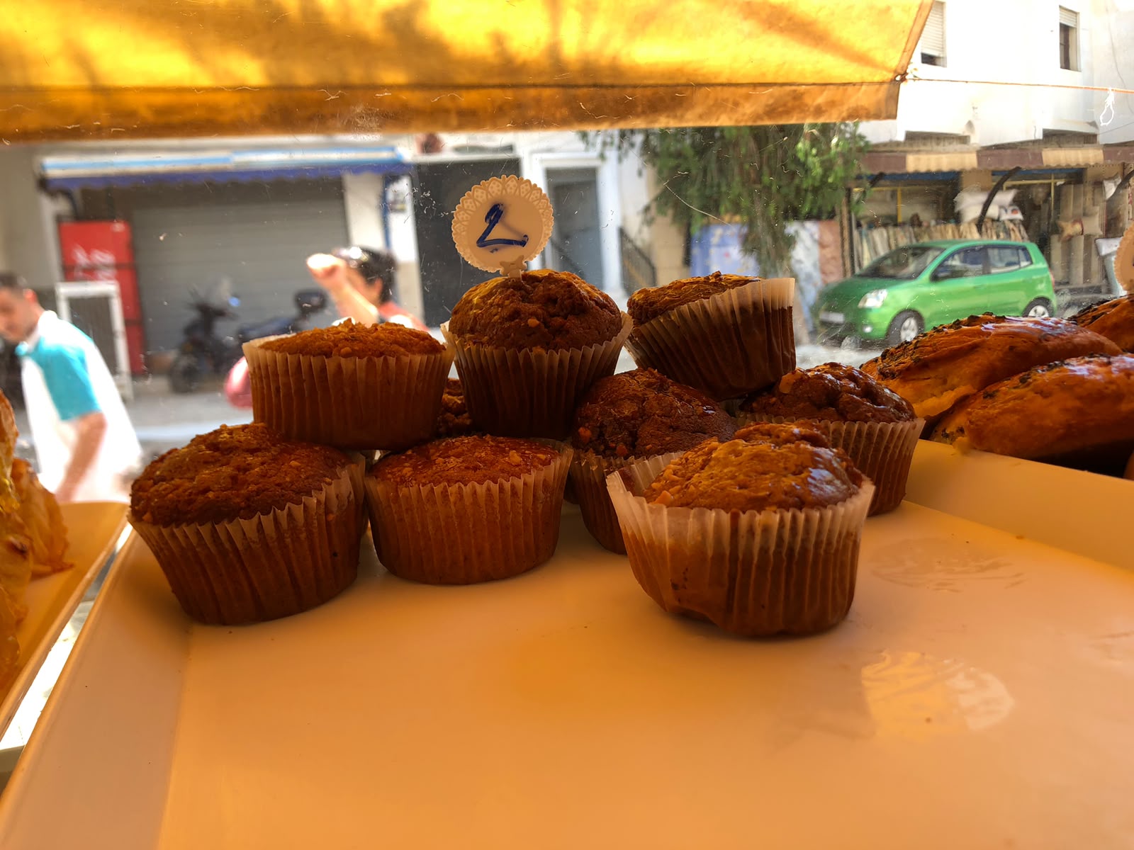 Fresh muffins stacked on a tray in the display case